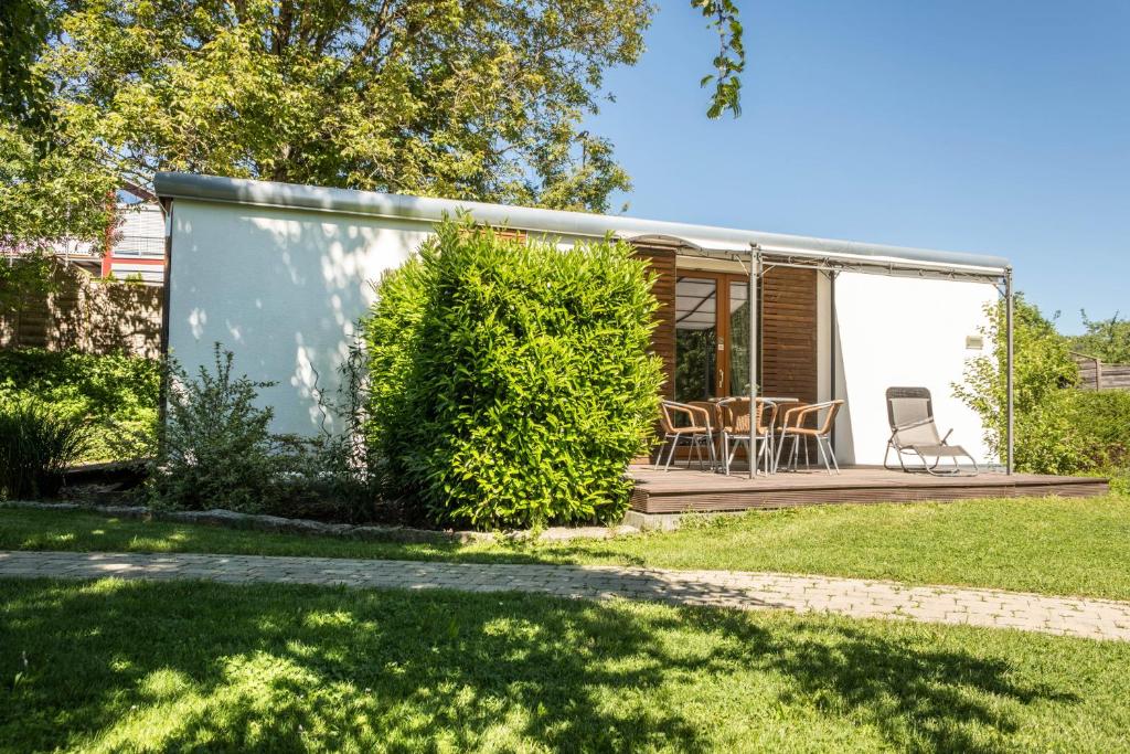 a tiny house with a deck and chairs at Ferienhaus Falkenhalde in Deggenhausertal