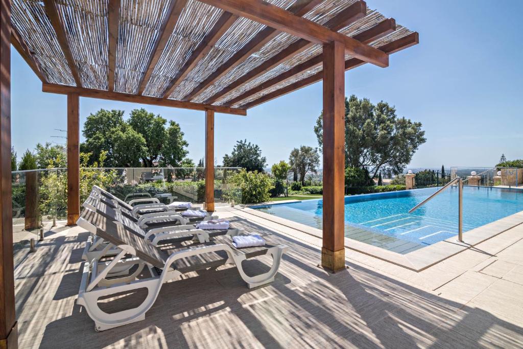 a patio with lounge chairs and a swimming pool at Apartment Mel de Flor in Loulé