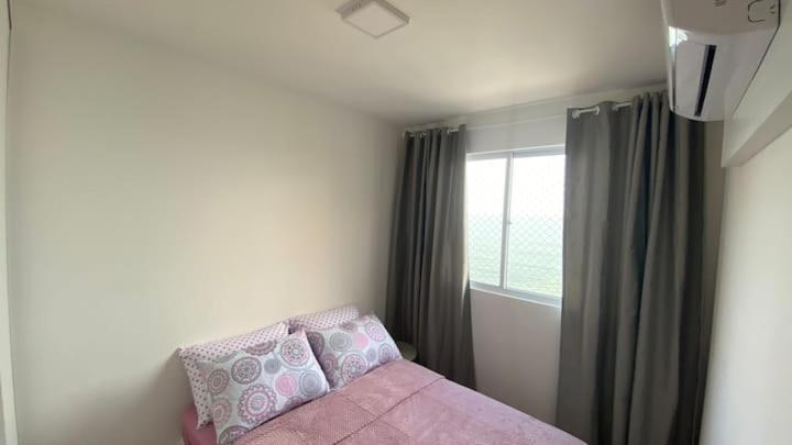 a bedroom with a pink couch and a window at Resort com vista mar! in Barra Velha