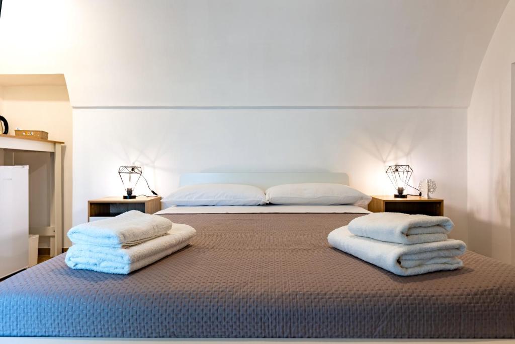 a bedroom with two beds with towels on the bed at Suite Le Cementine in Mottola