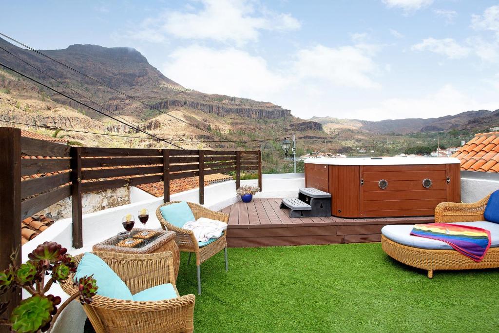 a deck with chairs and a hot tub with a view at La casa nueva in Fátaga