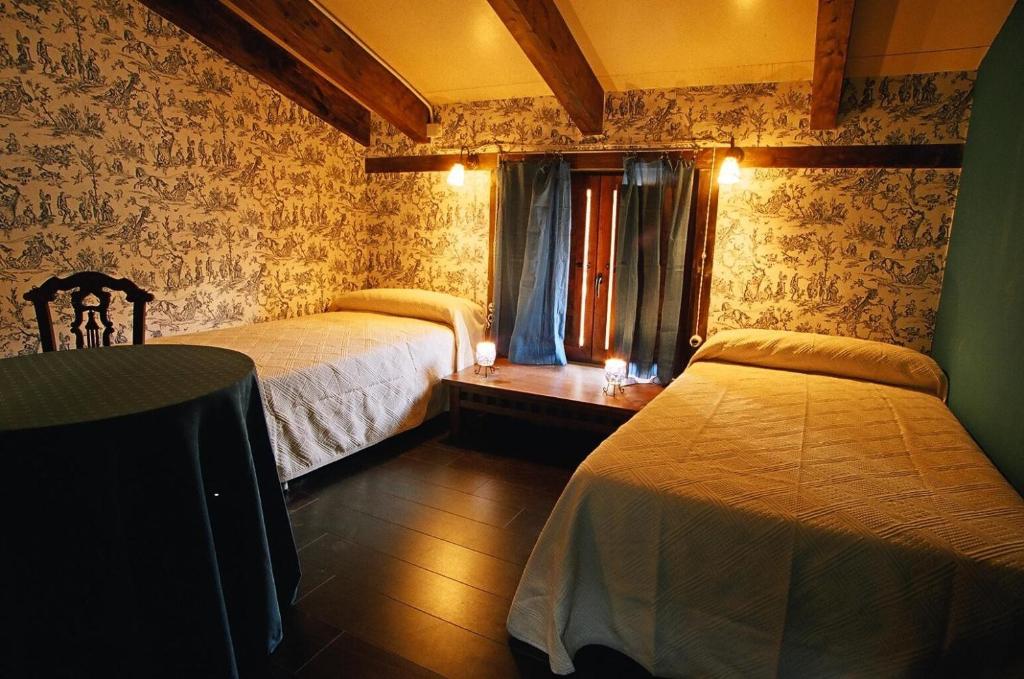 a bedroom with two beds and a table and a window at Reoyo 1 in Mambrilla de Castrejón