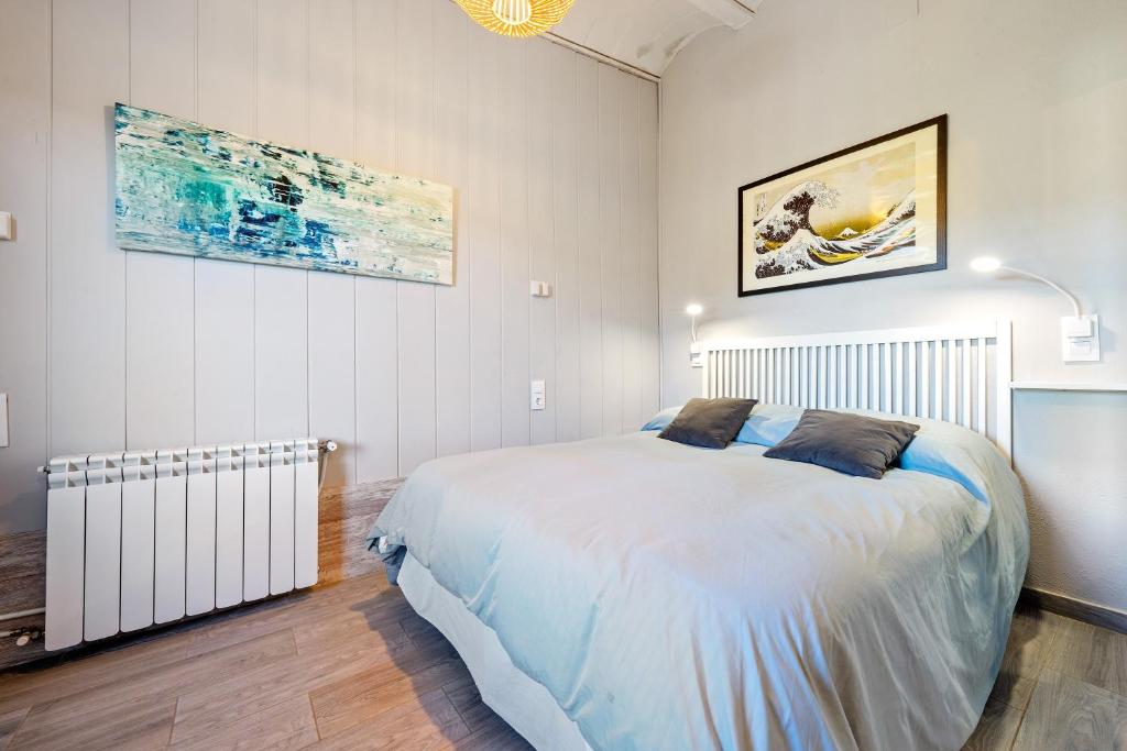 a bedroom with a bed and a painting on the wall at Habitacion Doble Jardin in Camarles