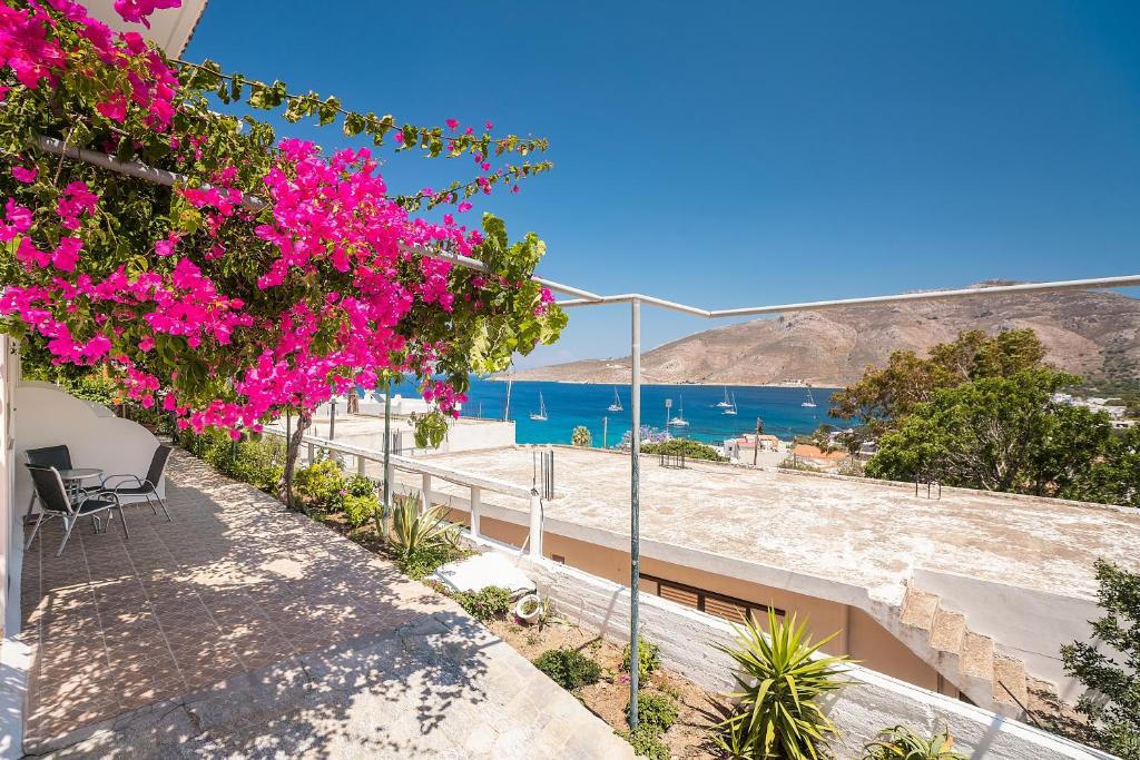 a view of the beach from a house with pink flowers at Panorama Tilos Apt B in Tílos
