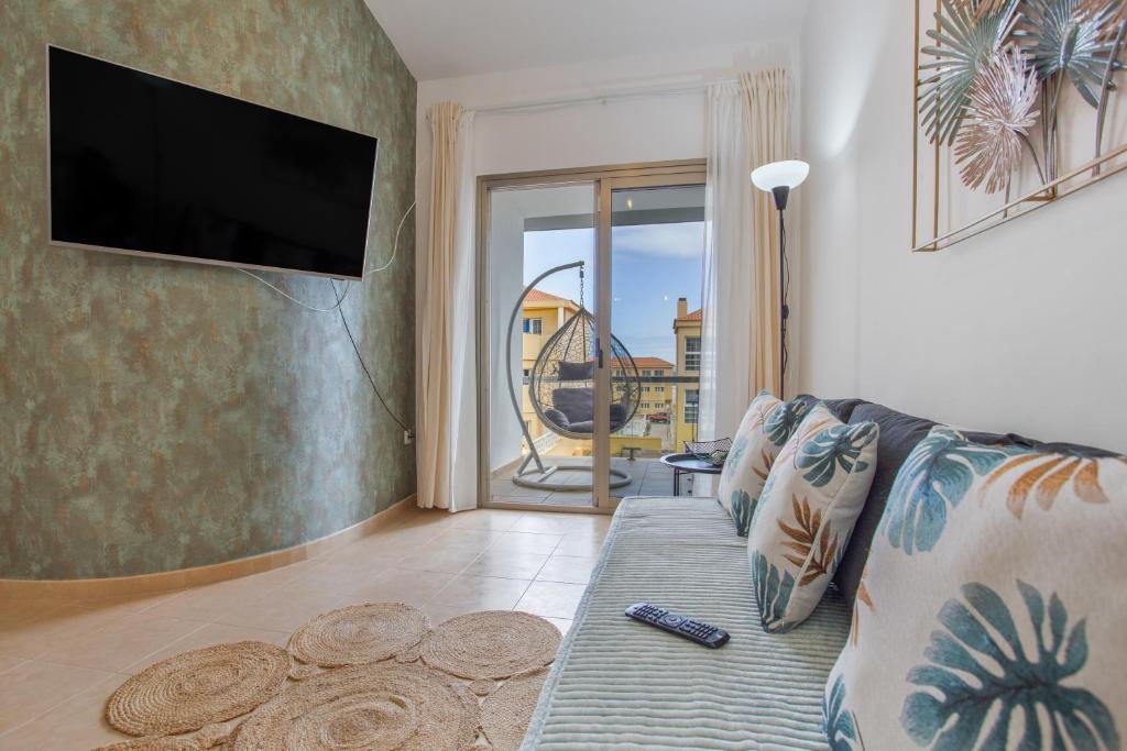 a living room with a couch and a flat screen tv at vv Sueño Del Mar in Costa de Antigua