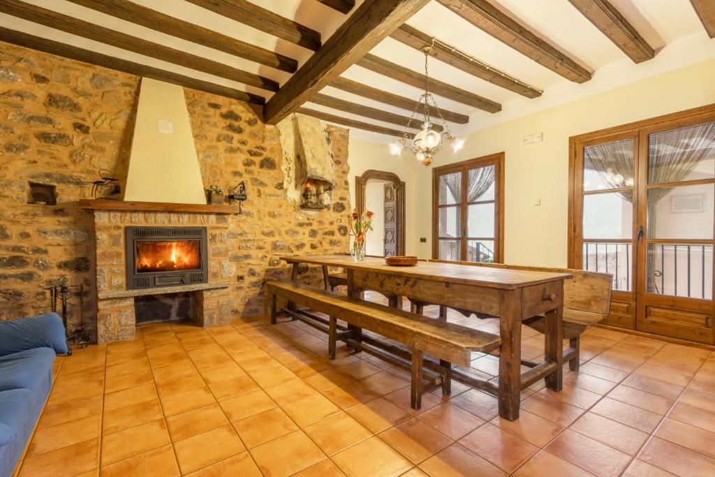 a dining room with a table and a fireplace at Casa Vilanova in Peramea