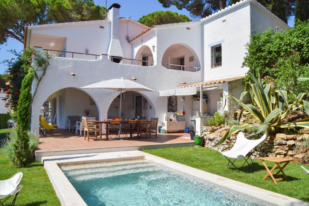 a villa with a swimming pool in front of a house at Puigvermell in Pals