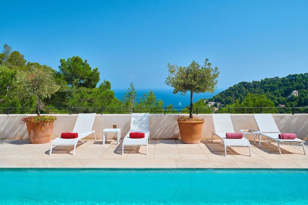 a group of chairs sitting next to a swimming pool at Can Pascalou in Canyamel