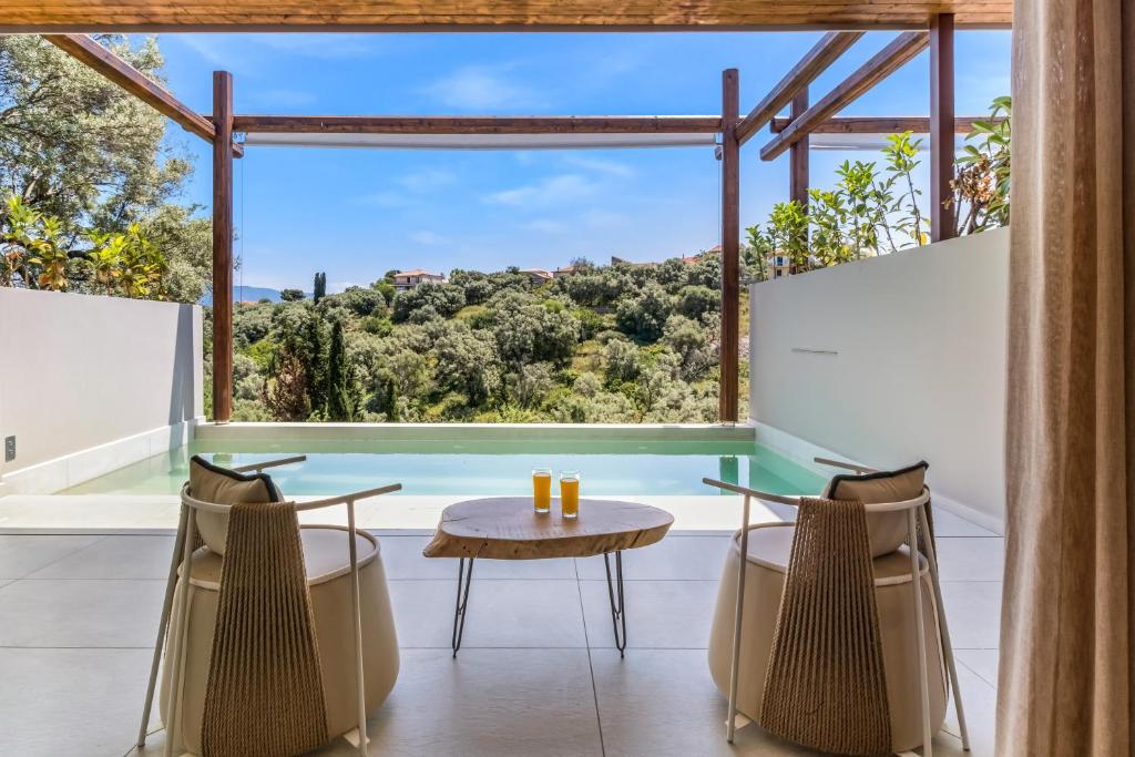 a room with a table and chairs and a large window at Studio Yvonne in Meganisi