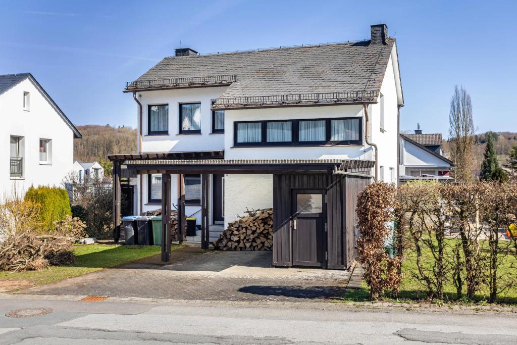 a large white house with a garage at Ferienwohnung am Kurpark Brilon in Brilon