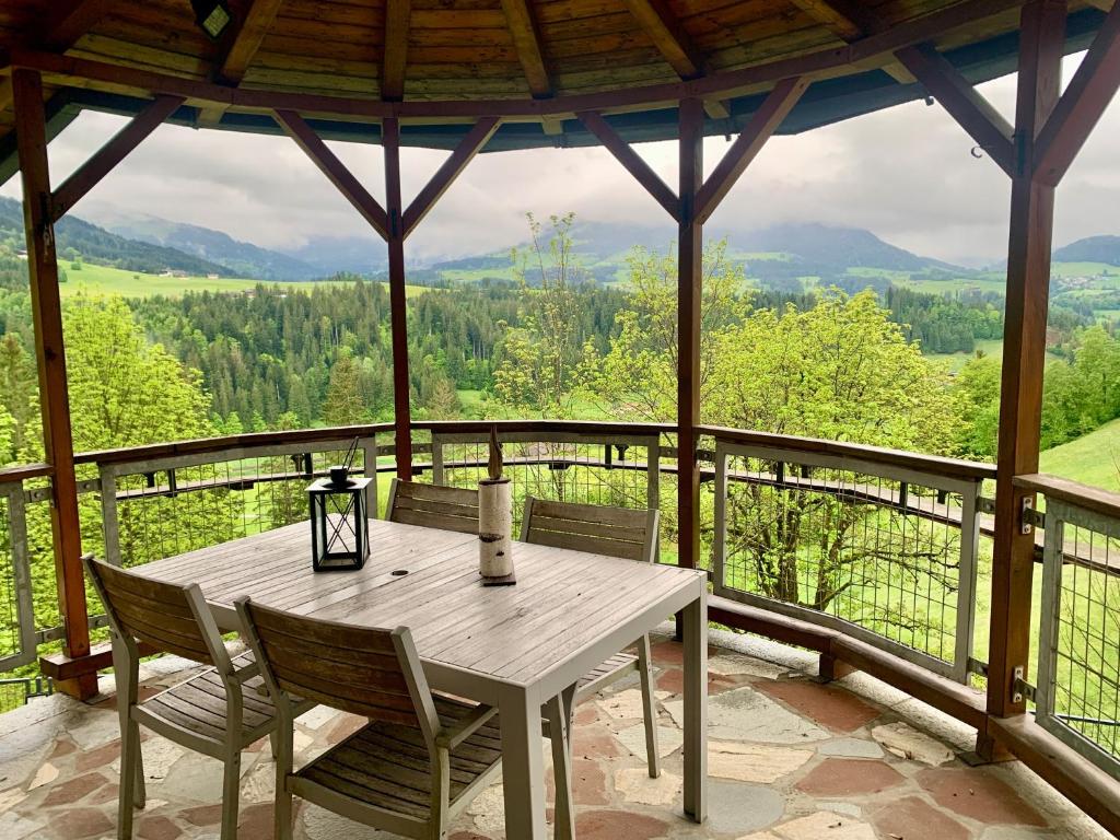 a wooden table and chairs on a porch with a view at Haus Auner Top 1 in Westendorf