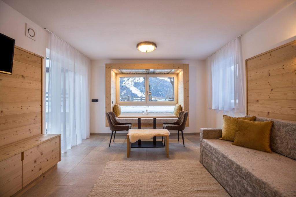 a living room with a table and a couch at Apartments Armeri Black Dolomites in San Vigilio Di Marebbe