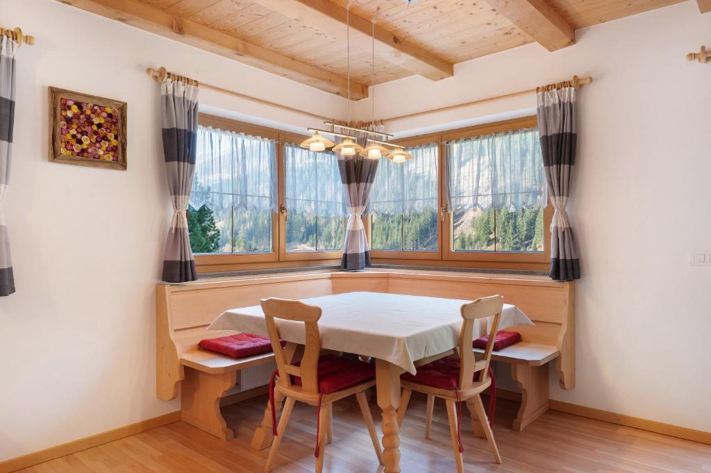 a dining room with a table and chairs and windows at Sprenghof Ferienwohnung in Sarntal