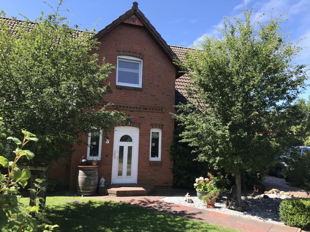 a red brick house with a white door at Ferienhaus Dohle in Vollerwiek