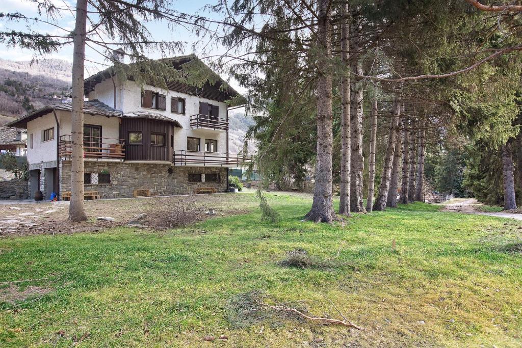 a house in the middle of a field with trees at Maison La Truite in Morgex