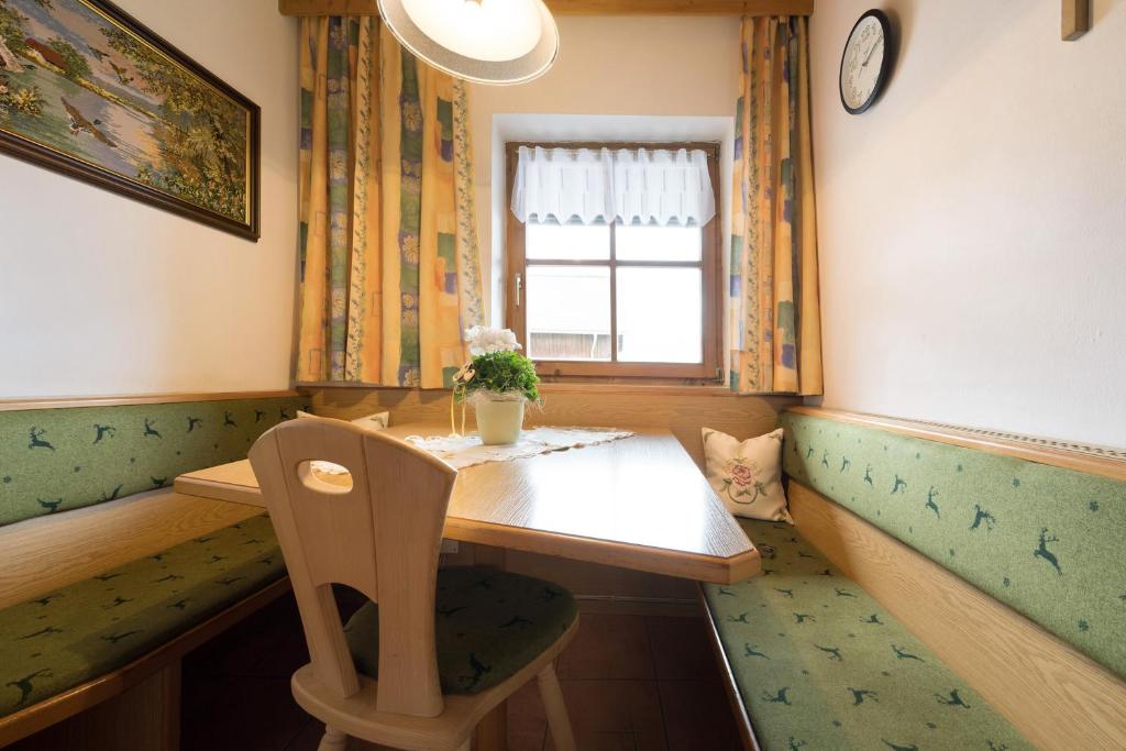 a room with a table and a chair and a window at Apartment Dolomitenblick in Mühlbach