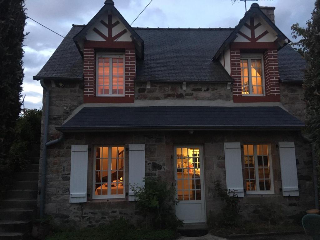 a house with lights in the windows at night at Maison dans la prairie in Plurien