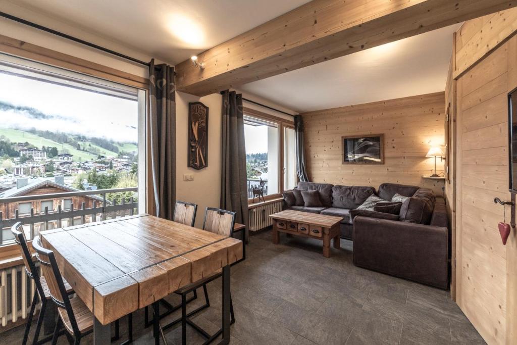 a living room with a couch and a table at Appartement au centre de megève in Megève