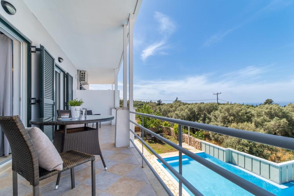 a balcony with a table and chairs and a pool at Apartment with Sea view B in Tsoukalades