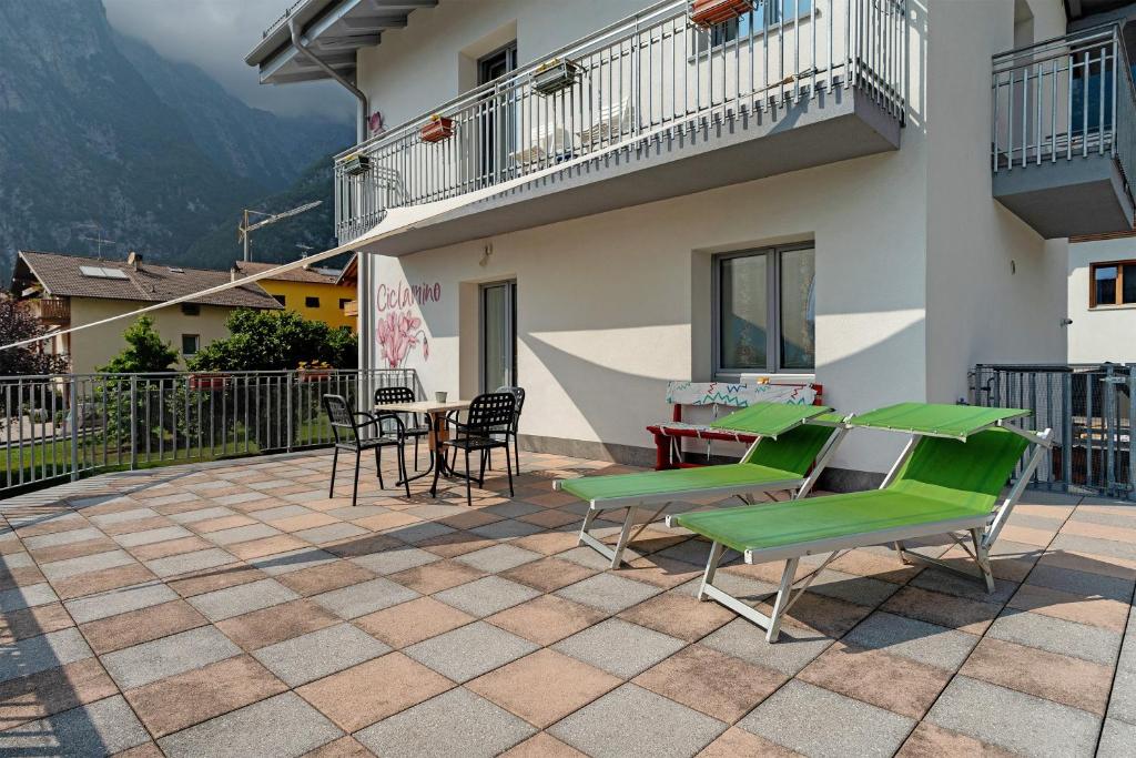 a patio with green chairs and a table and chairs at Ciclamino Superior Otto in San Lorenzo in Banale