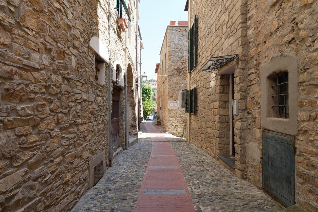 an alley in an old town with stone buildings at Villa sole e mare in Cipressa