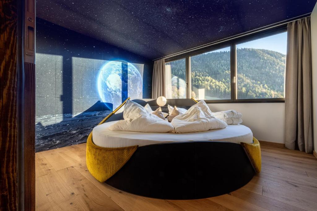 a bed in a room with a large window at Sonnleiten Sonne Mond u Sterne in Collepietra