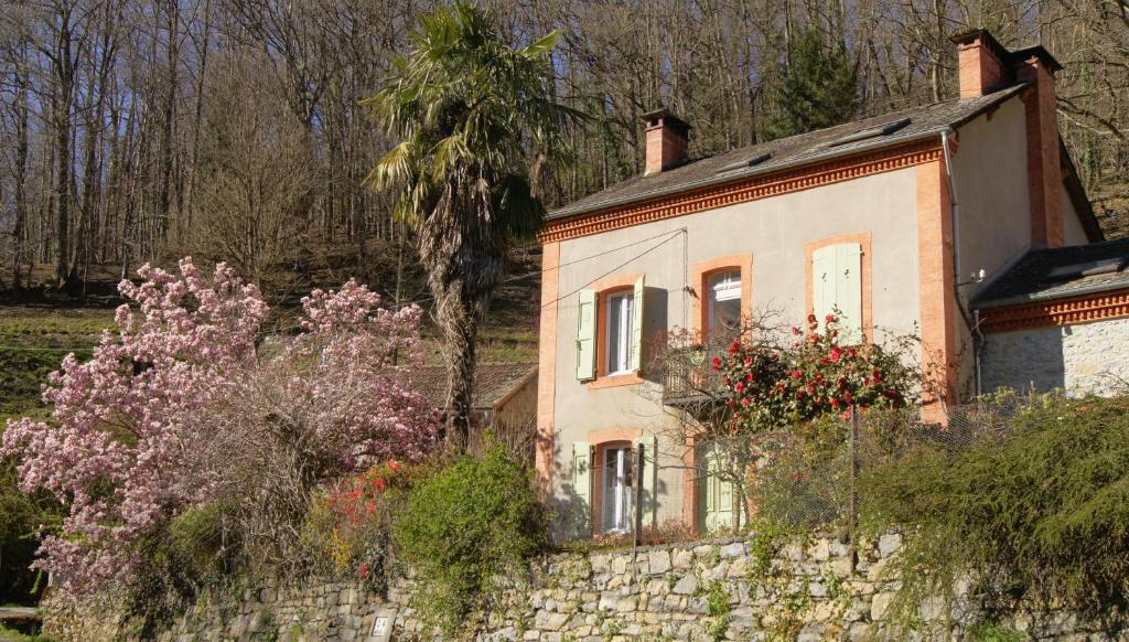 an old house on a stone wall with flowers at Gite Decauville in Uchentein