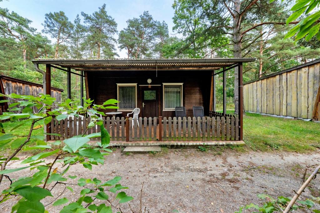 a small cabin with a fence and a porch at Bungalow 34 - Kimbucht in Reichendorf