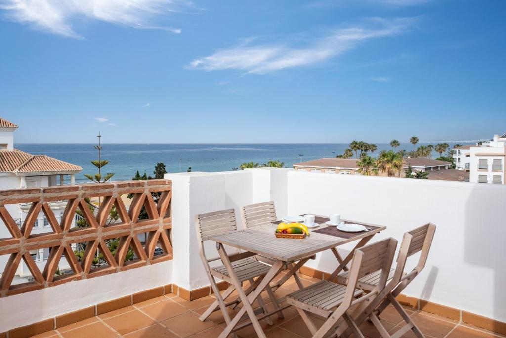 a table and chairs on a balcony with the ocean at Ático el morche in El Morche