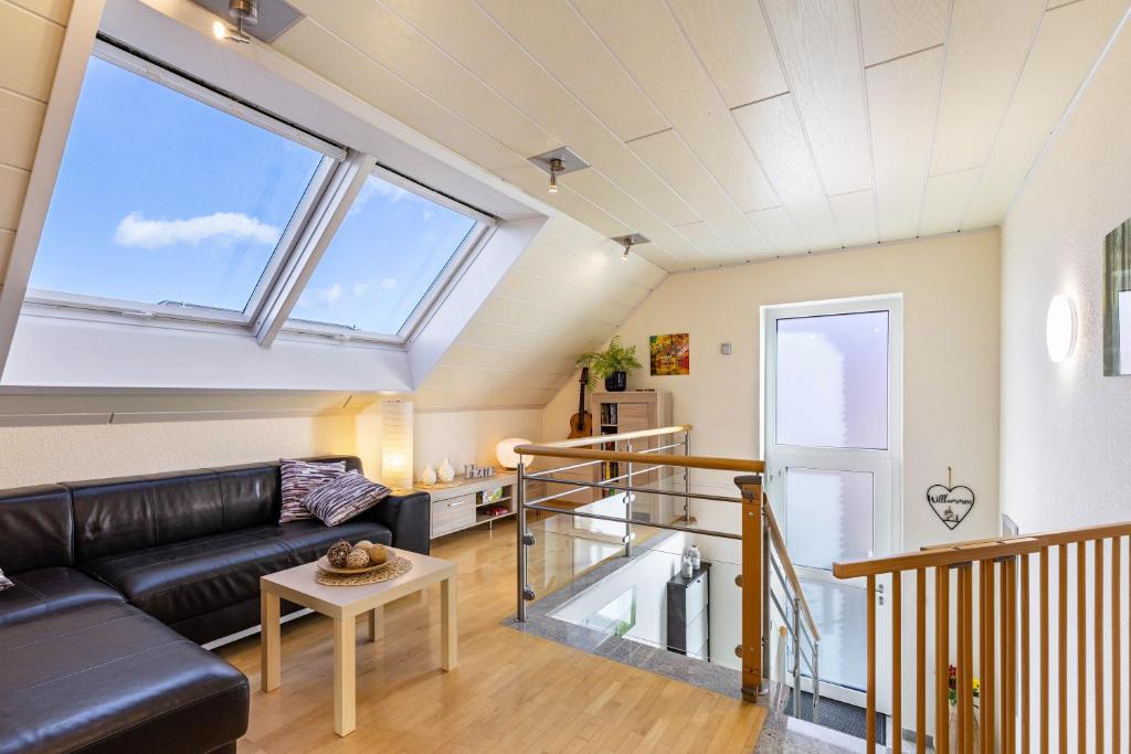a living room with a black leather couch and a large window at Ferienwohnung Luri in Gangelt