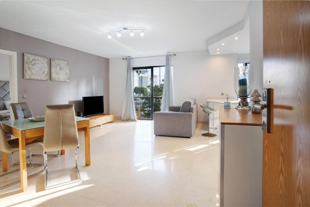 a kitchen and living room with a table and a dining room at Apartamento Forum View in Funchal