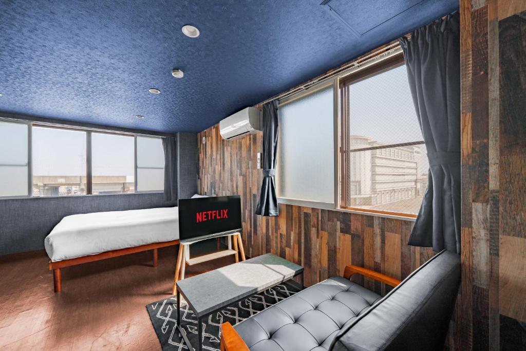 a room with a bed and a couch and windows at Silk Court 402 in Chitose