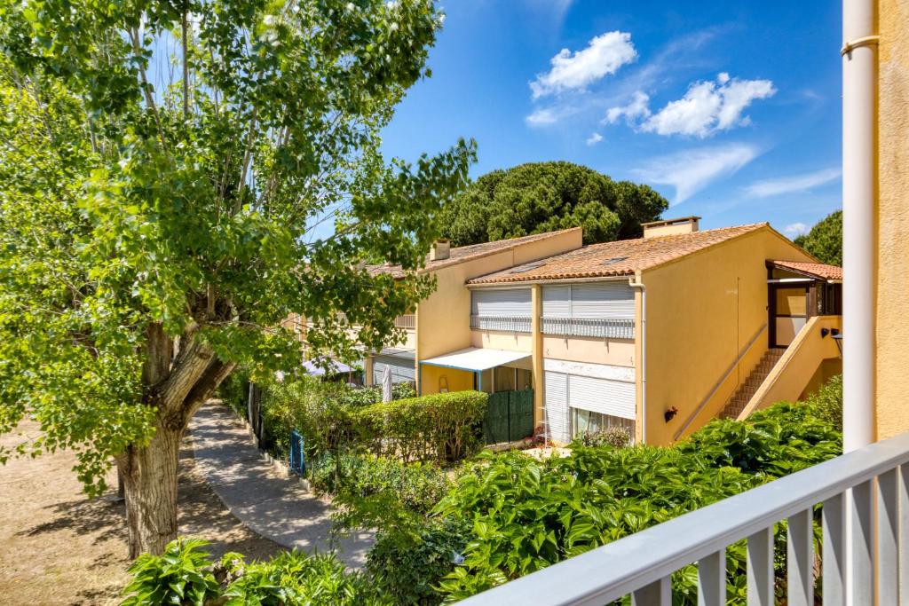 a house with a white fence and trees at Les Saules in Le Grau-dʼAgde