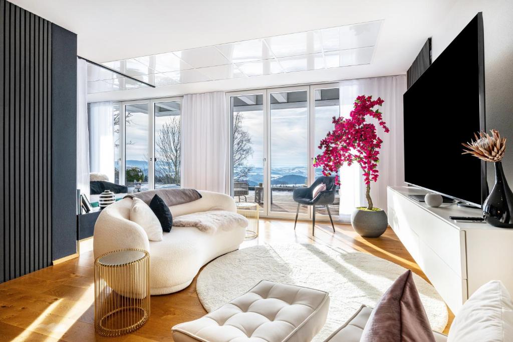 a living room with white furniture and a large window at Apartment Himmelweit in Freyung