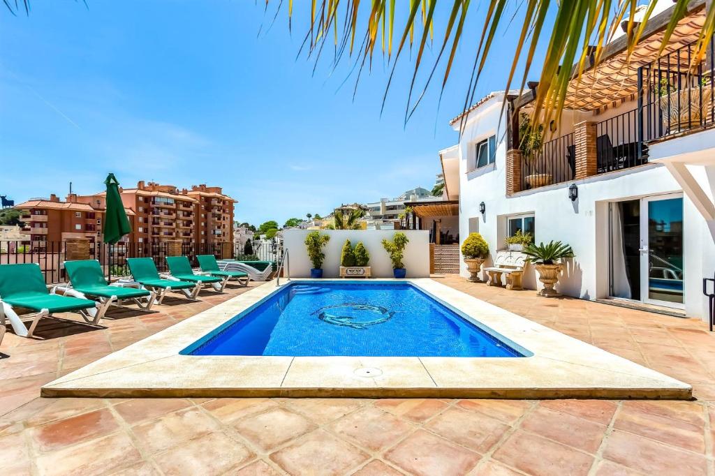 a swimming pool in the middle of a patio with chairs at Studio Torreblanca close to beach in Fuengirola