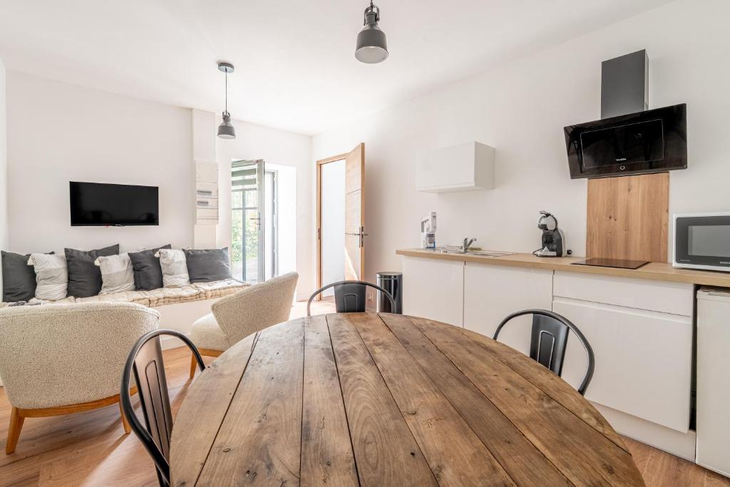 a kitchen and dining room with a wooden table and chairs at L'écrin De La Sèvre in Cugand