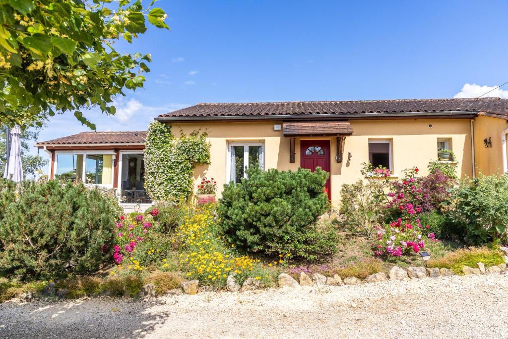 a house with flowers in front of it at Maison de vacances proche de Sarlat in Carsac-Aillac