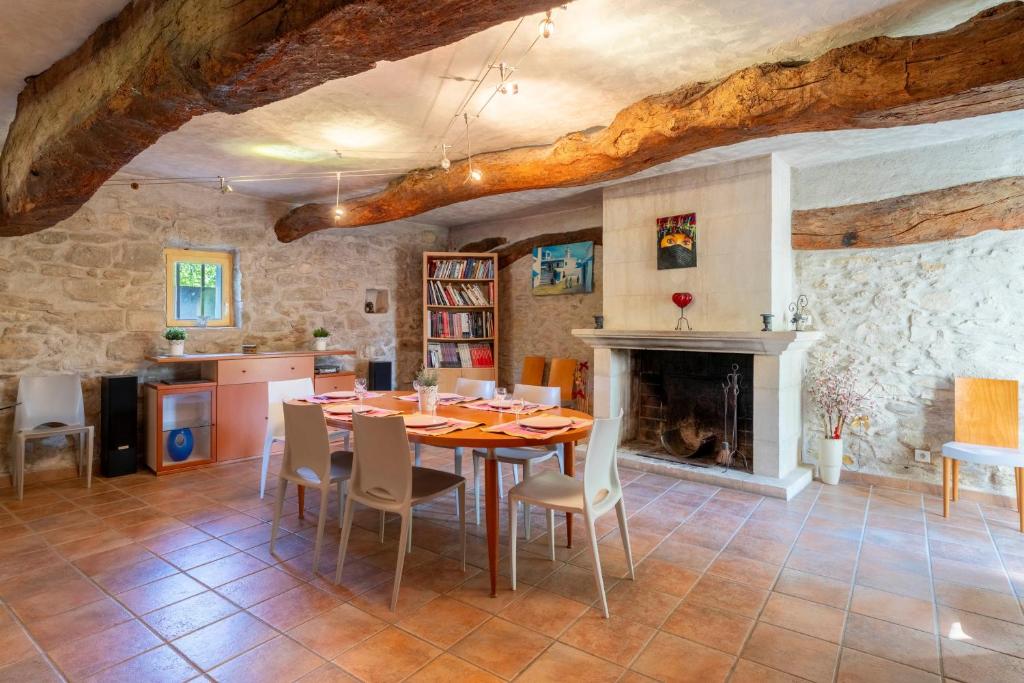 a dining room with a table and a fireplace at Mas De Charme Caumont Sur Durance in Caumont-sur-Durance