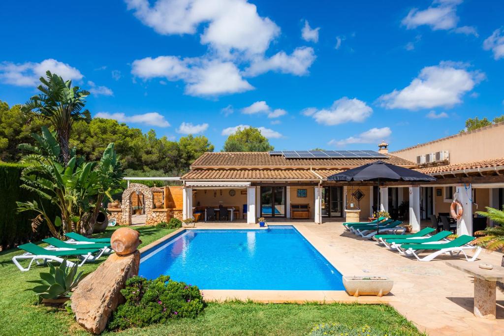 a villa with a swimming pool and lawn at Casa Toni in Portocolom
