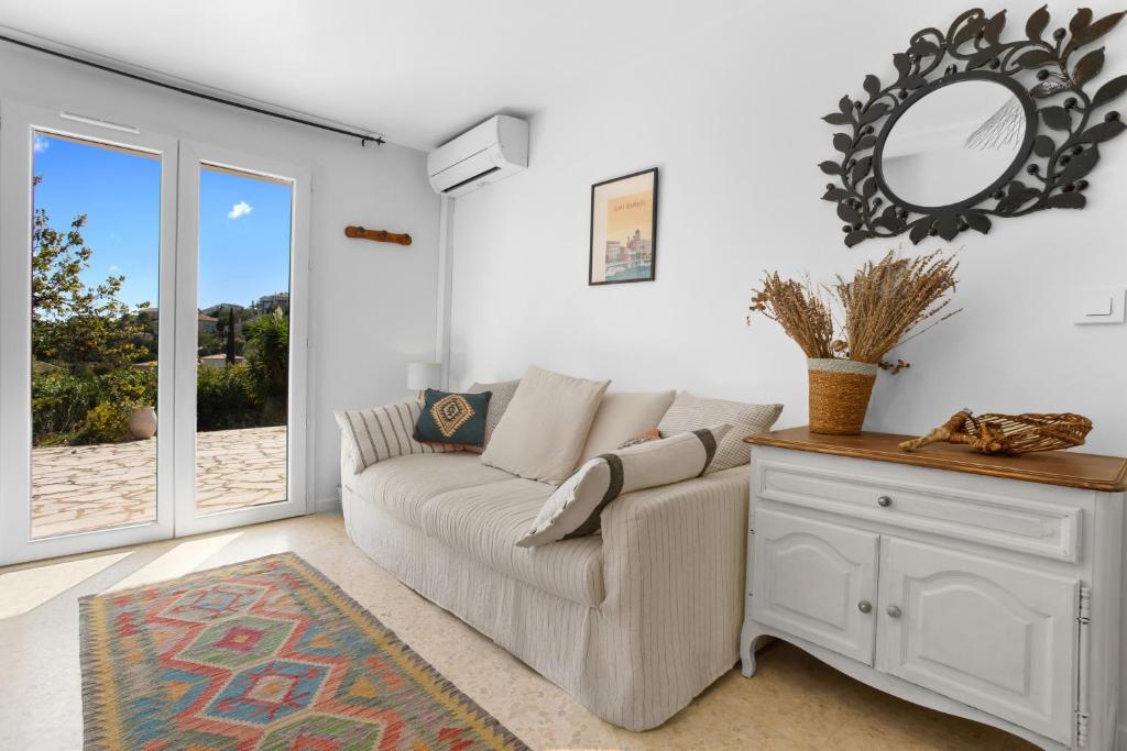 a living room with a couch and a mirror at Rez de villa avec jardin vue mer in Fréjus