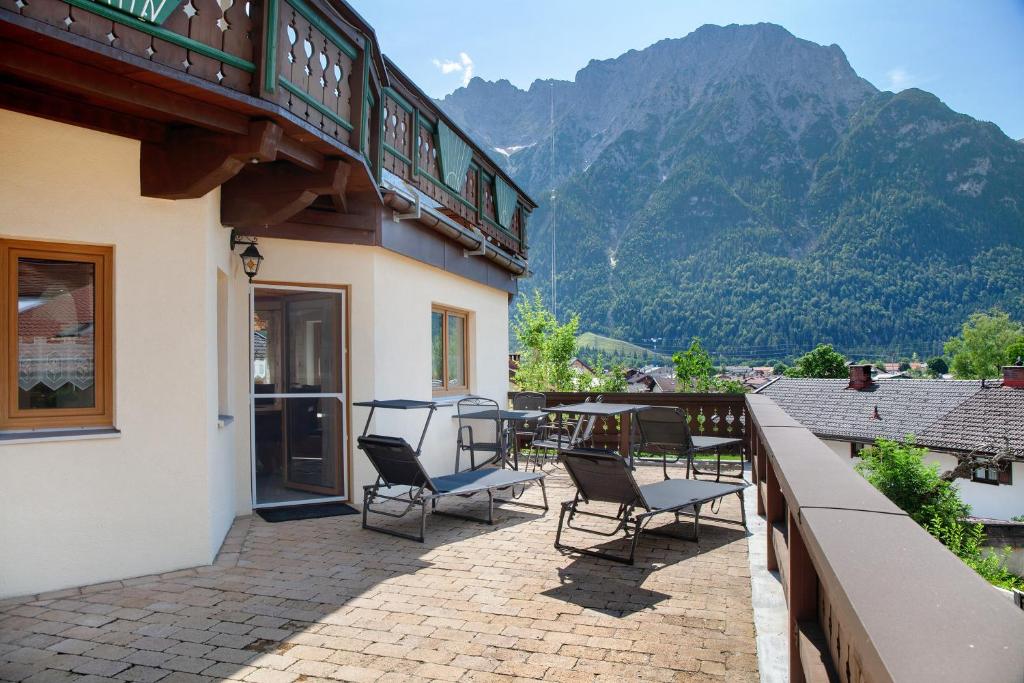 a patio with chairs and a table on a balcony at Ferienwohnung Lapislazuli in Mittenwald