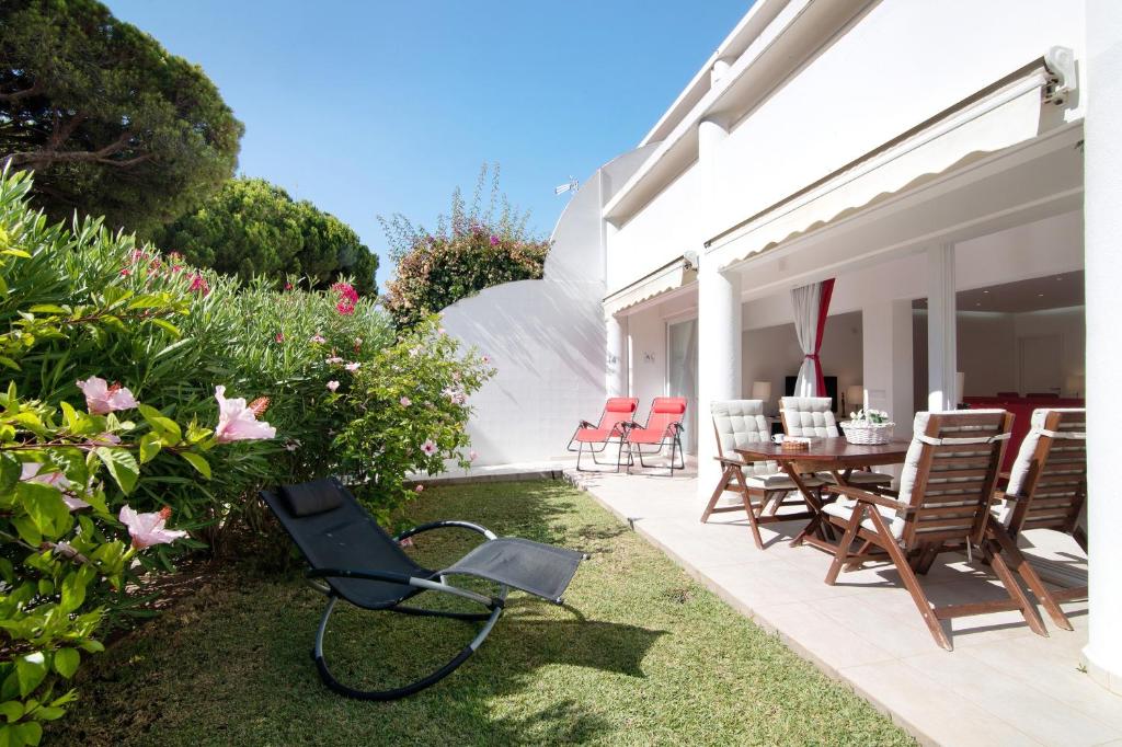 a patio with a table and chairs in a yard at Large apartment in Vale do Lobo in Almancil