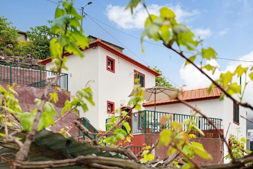 a white building with a red roof at São Vicente House in São Vicente