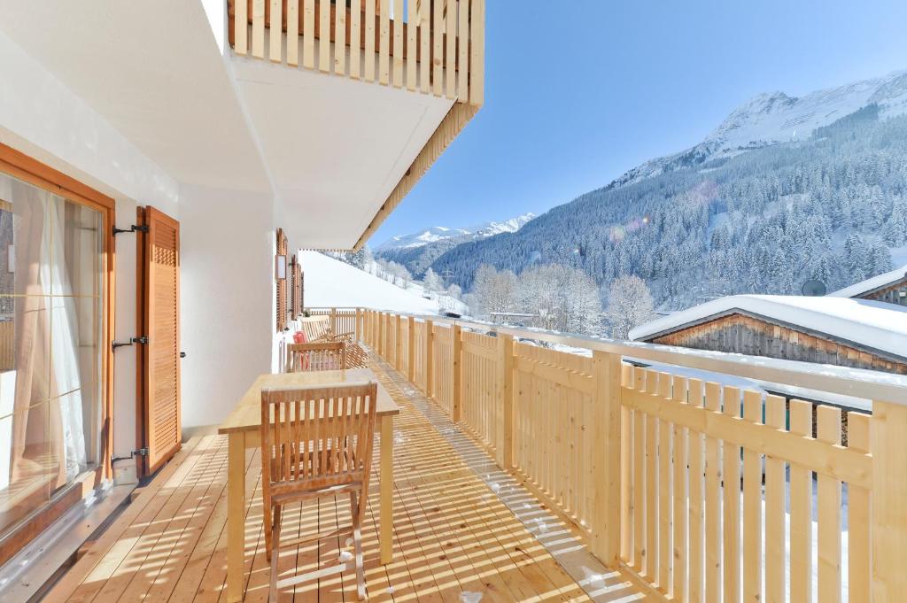 a balcony with a table and chairs and mountains at Ferienhaus in Klösterle in Klösterle