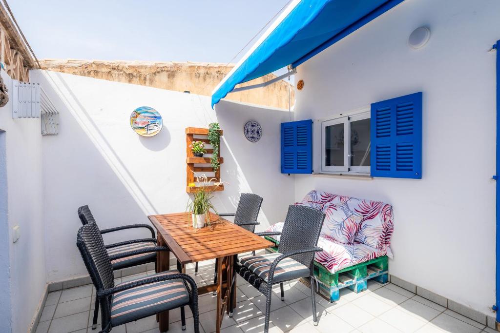 a patio with a wooden table and chairs at Es Cantonet in Porto Cristo