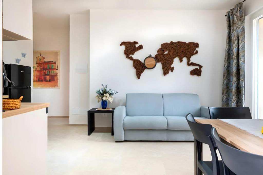 a living room with a blue couch and a map on the wall at Helianthus in Cisternino