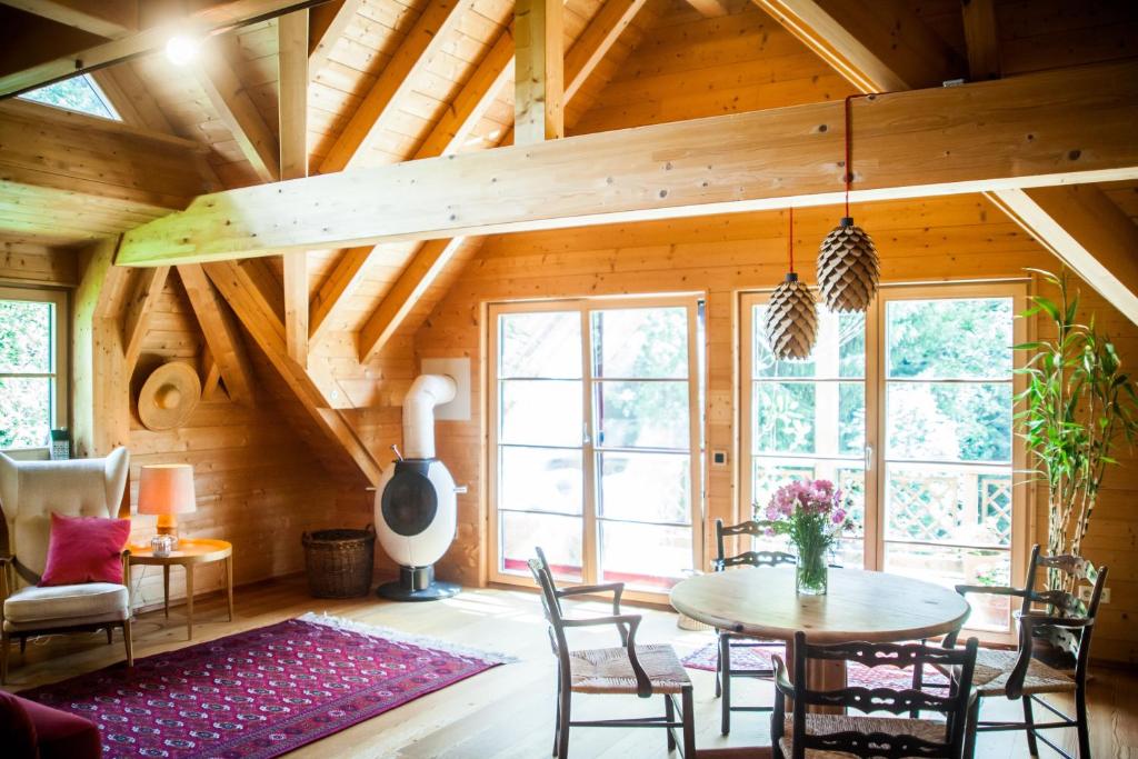 a room with a wooden ceiling with a table and chairs at Ferienwohnung am Hirschenmoor in Breitnau
