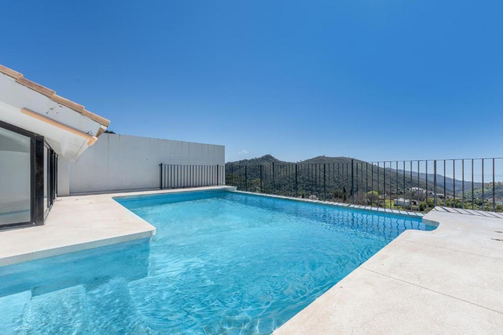 a swimming pool on the roof of a house at Dúplex Bellas Vistas in Ojén