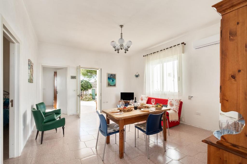 a dining room and living room with a table and chairs at Villa Privata Spiaggia Del Sole in Porto Cesareo
