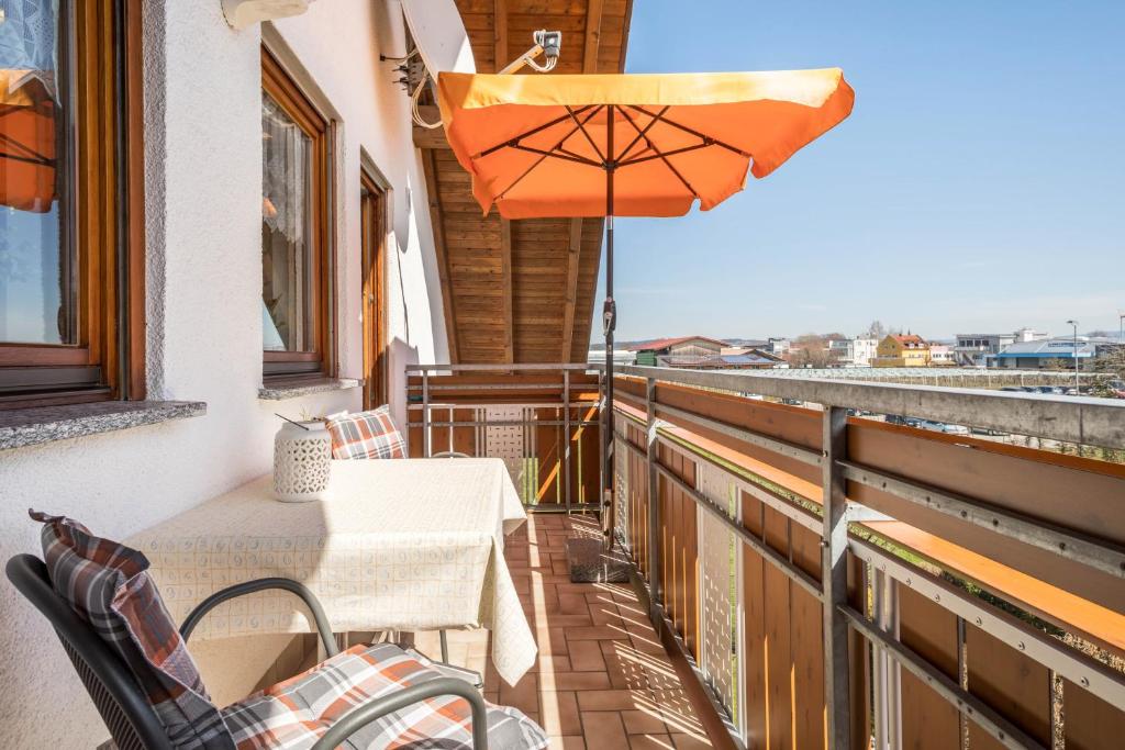a balcony with a table and an umbrella at Ferienwohnung Monninger in Langenargen